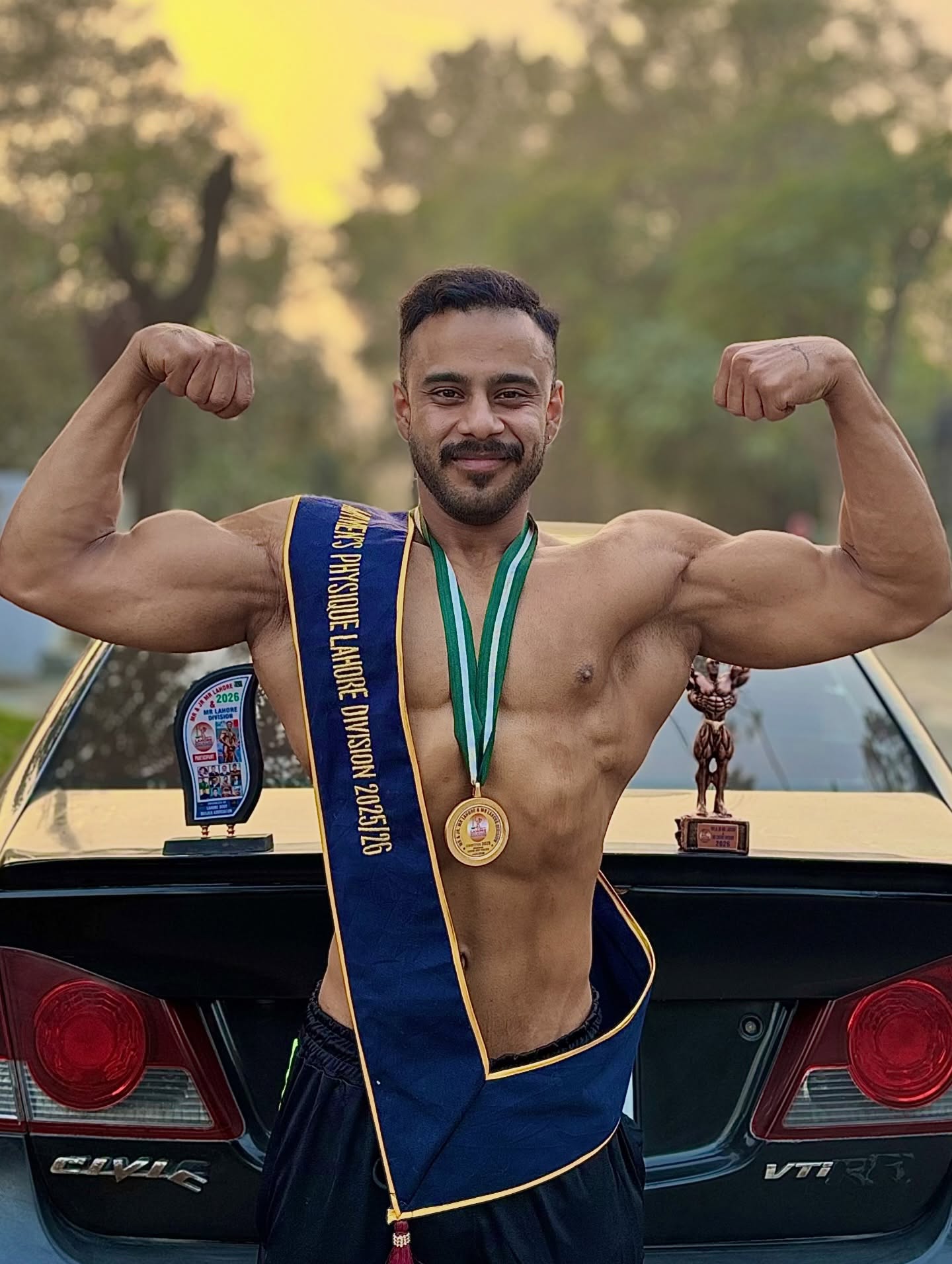 Syed Abdul Haseeb with his Men's Physique medal and trophies