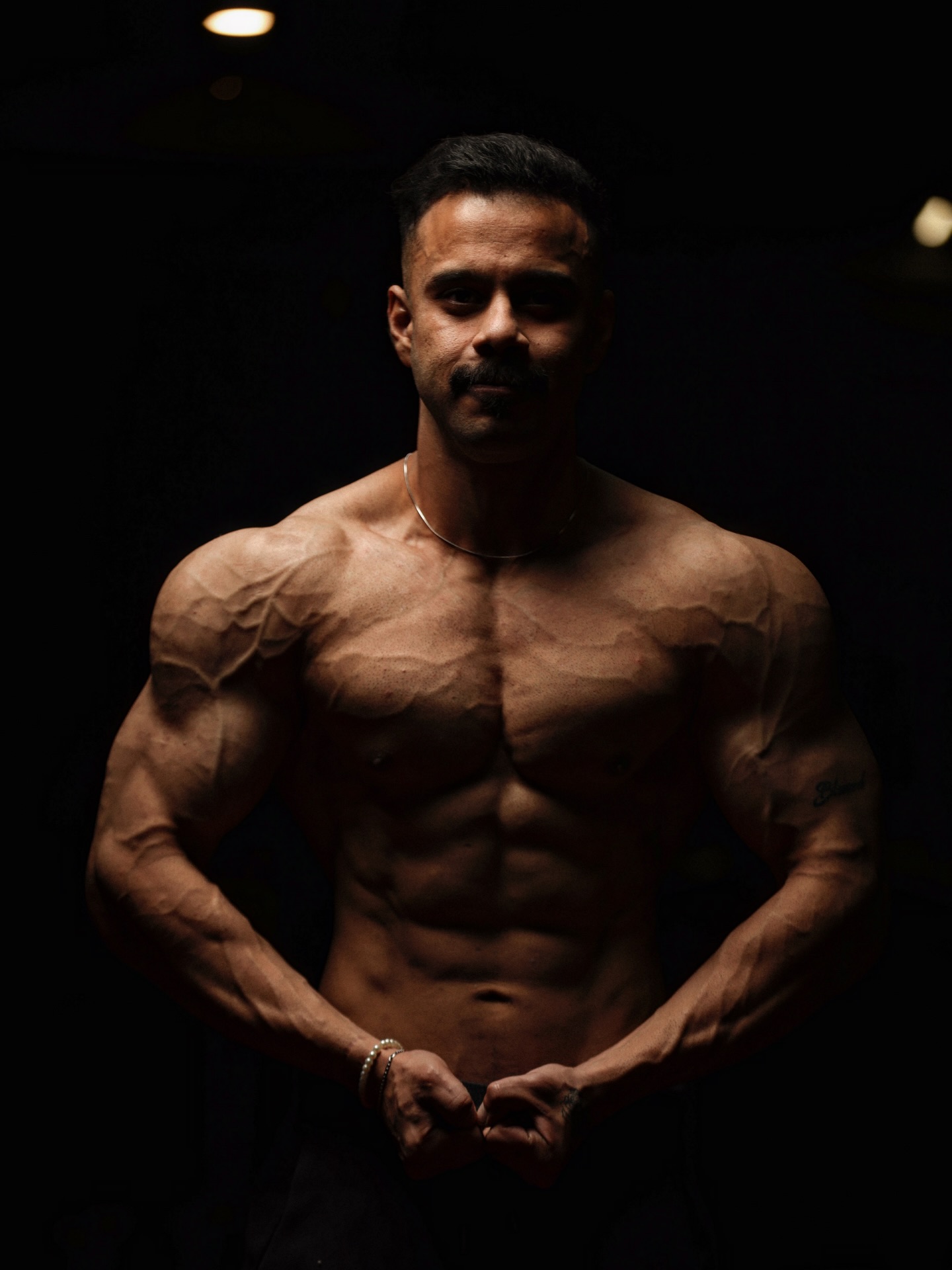 Syed Abdul Haseeb, Mr. Lahore Men's Physique, posing under stage lighting